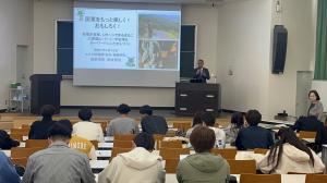 市長が大分大学の学生たちにプロジェクターを使用しながら話しています