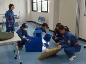 段ボールベッド作成中の女性団員の画像