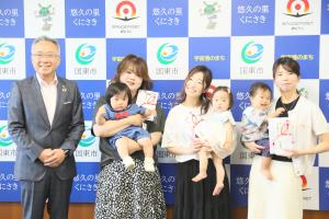 市長と、１歳になったお子様とその保護者の方々が並んでいます