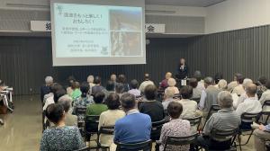 市長がプロジェクターを使用しながら講演しています