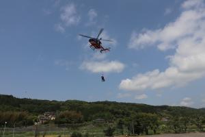 消防隊員が防災航空隊員と共に降下している画像