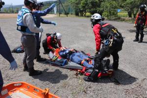 防災航空隊員へ傷病者を引き継いでいる画像