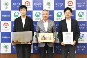 塩塚隆生アトリエの方と市長が、賞状と盾を持って並んでいます