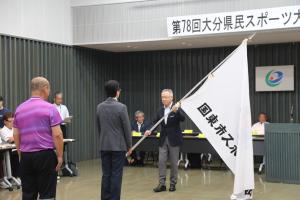 市長が教育長へ応援団旗を渡しています