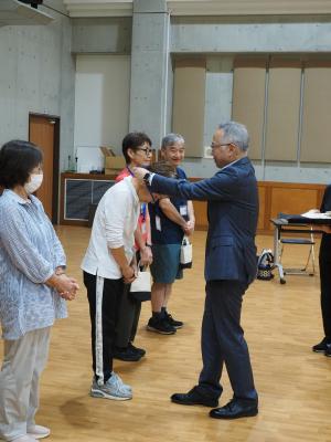 普及リーダーとなった方々に市長が証書を首にかけています