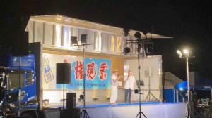 市長がステージ上で司会者と話しています