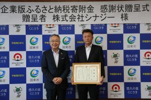 市長と株式会社シナジーの方が並んでいます