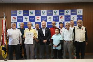 市長を囲んで、優勝旗を持ったグラウンドゴルフ部のみなさんが笑顔で並んでいます。