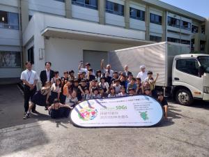 高純度バイオディーゼル燃料車両になった学校給食の配食車両の前で撮られた国東小学校4年生と市職員らの集合写真