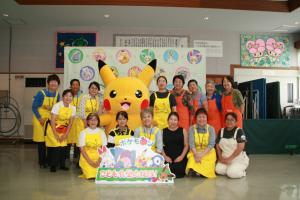 ピカチュウと「なっちゃんの家」のスタッフの集合写真