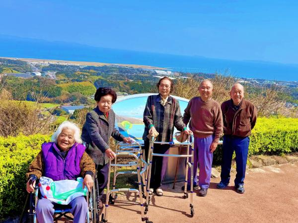 あおぞらを背にしたおばあさん3人、おじいさん2人の写真