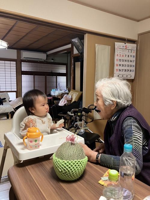 ひ孫に「あーん」してもらおうとするおばあさんの写真