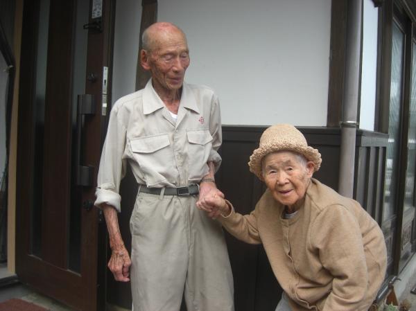 帰宅したおばあさんを迎えるおじいさんの写真