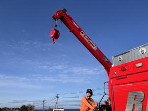 救助工作車の運転手がサングラスを着用してクレーン操作をしている画像
