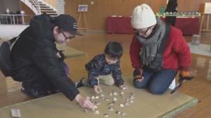 弥生のムラ七日正月で、貝に描かれた絵を合わせる昔の遊びを楽しむ親子