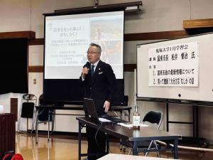 市長がプロジェクターを使用しながら講演しています