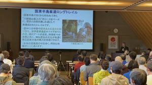 市長がプロジェクターを使用しながら講演しています