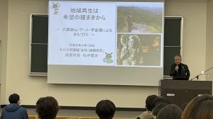 市長がプロジェクターを使用しながら講演しています