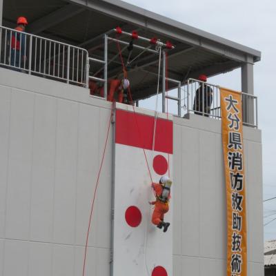 隊員が地上からロープを使用し塔を昇っている画像