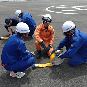 消防職員からホースの巻き方を教わっている画像