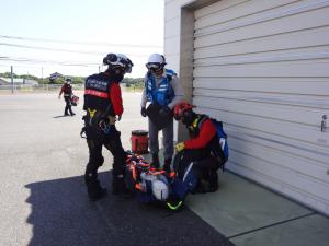 救急隊員と防災航空隊の隊員が引き継ぎをしている画像