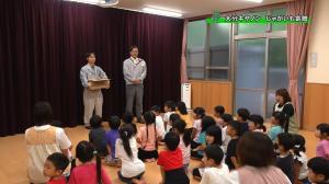 関係者がじゃがいもを持って園児の前に立っている画像