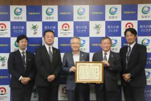 市長と株式会社オーイーシーの皆様が並んで記念撮影をしています