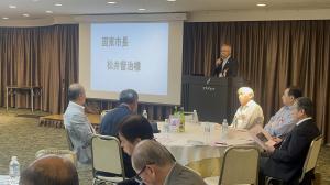 市長がプロジェクターを使用しながら講演しています