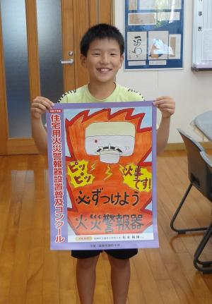 作品を掲げて記念写真をしている画像